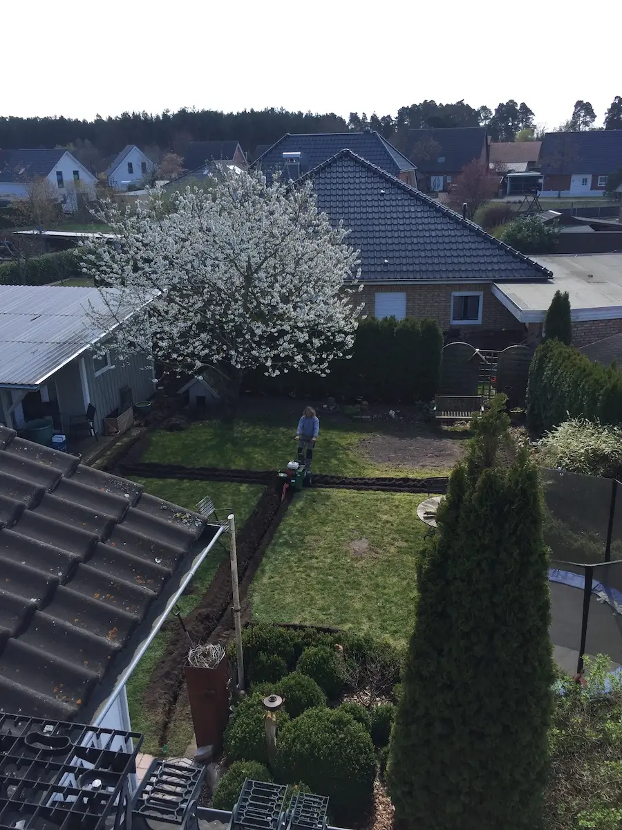 Luftbild eines Privatgartens mit Rasenflächen, Beeten und Terrasse