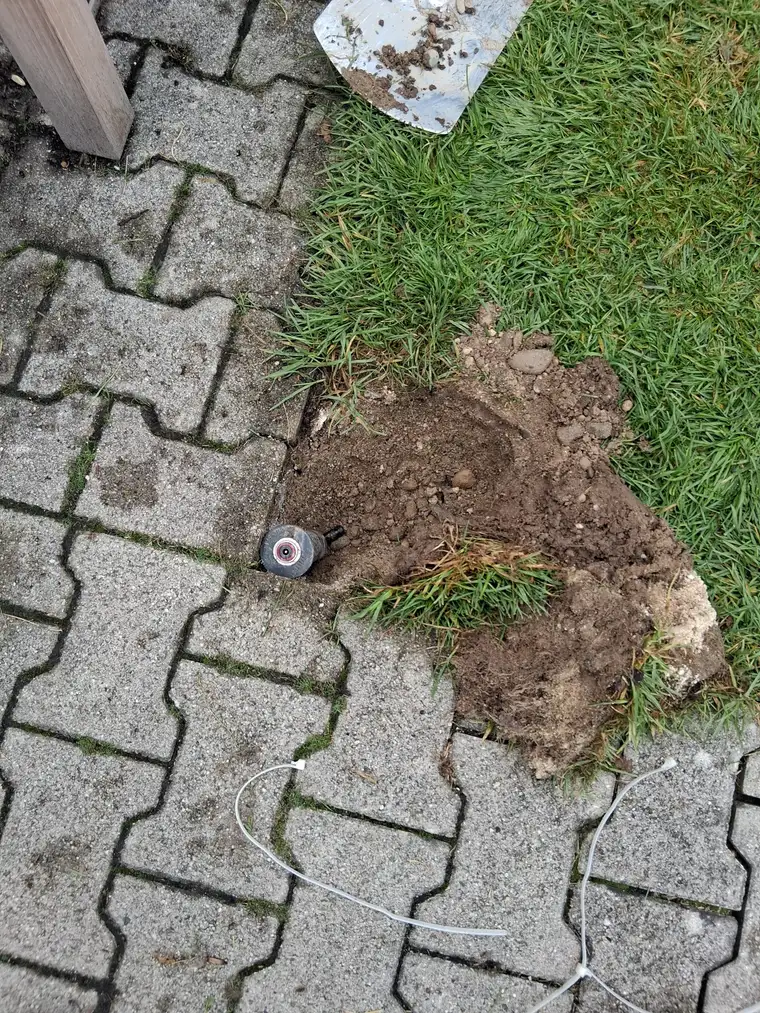 Versenkregner bündig im Pflaster einer Rasenkante eingebaut