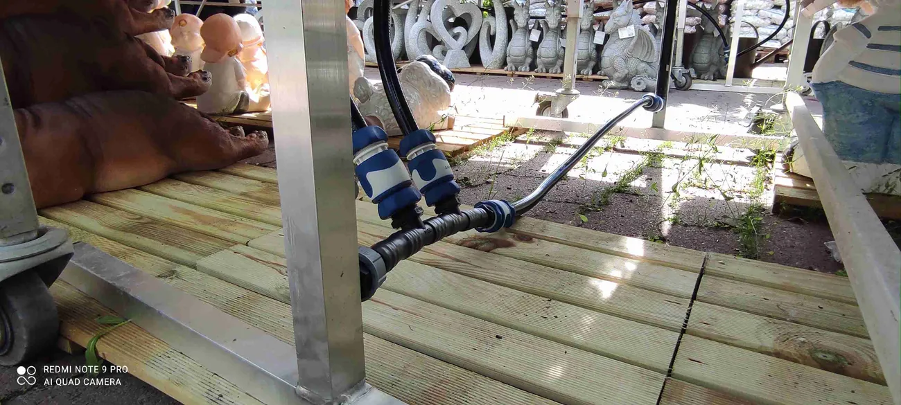 Wasseranschluss mit Schlauch unter einem Pflanztisch