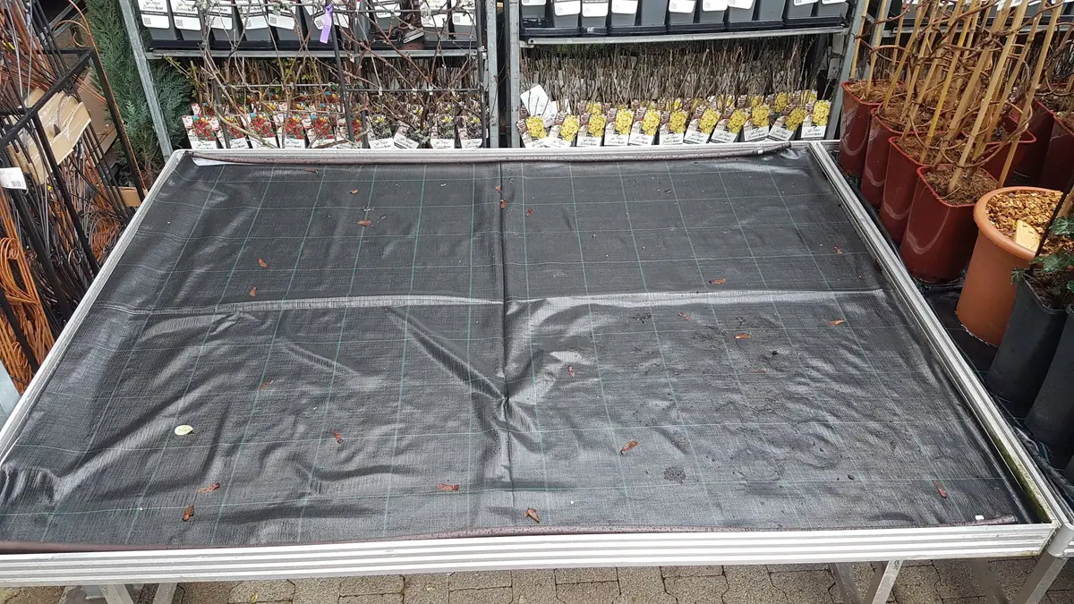 Pflanztisch im Gartencenter mit eingelegter Bewässerungsmatte in der Wanne